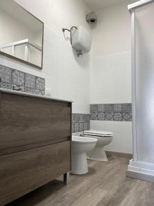 ein Badezimmer mit einem WC, einem Waschbecken und einem Spiegel in der Unterkunft appartamento dell'anfiteatro in Spoleto