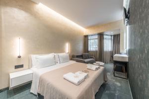 a hotel room with a bed with towels on it at Piazza Luxury Apartments in Tirana