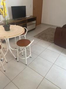 salon ze stołem, krzesłami i telewizorem w obiekcie Ap térreo w mieście Uberlândia