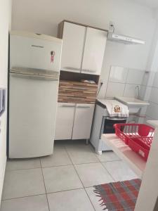 kuchnia z białymi szafkami i lodówką w obiekcie Ap térreo w mieście Uberlândia