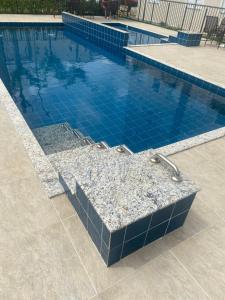 basen z niebieską podłogą wyłożoną kafelkami i brodzikiem w obiekcie Ap térreo w mieście Uberlândia