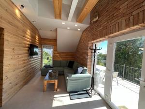 un soggiorno con pareti in legno e divano di NEON Apartman Csopak Balaton a Csopak