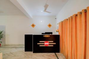 a row of orange curtains in a room at OYO Flagship Hotel Anvi in Bhubaneshwar
