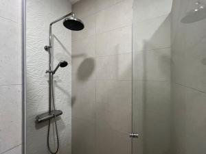 a shower with a glass door in a bathroom at NEON Apartman Csopak Balaton in Csopak