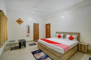 a bedroom with a large bed with red pillows at OYO Flagship Hotel Anvi in Bhubaneshwar