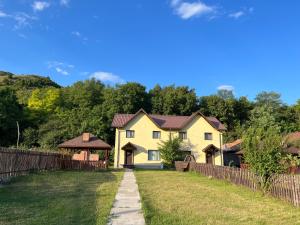 a house in a yard with a fence at Vila Maria in Buzau