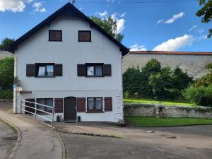 a white house with black windows and a driveway at Naturoase in Inzigkofen