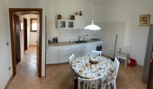 eine Küche mit einem Tisch und Stühlen sowie eine Küche mit einem Tisch und einem Tisch in der Unterkunft Casa Andrea in Torre Pali 