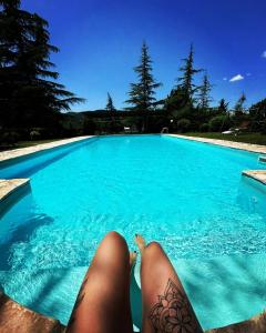 una mujer en el borde de una piscina en Antico Casale '700 appartamento GIRASOLE, en Umbertide