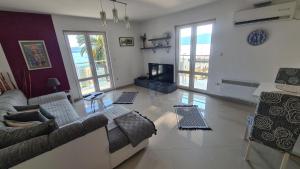 a living room with a couch and a tv at Chic apartment in the City Center by the sea in Tivat