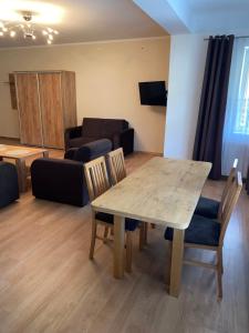 a living room with a table and chairs and a couch at Zajazd Kadar in Wisła