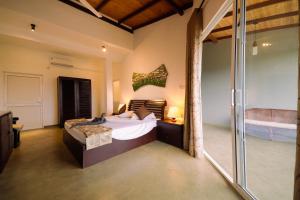 Schlafzimmer mit einem Bett und einer Glasschiebetür in der Unterkunft The Hills By Blue Fox in Kandy