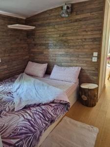 Cama en habitación con pared de madera en Au fils de l'eau en Estrasburgo