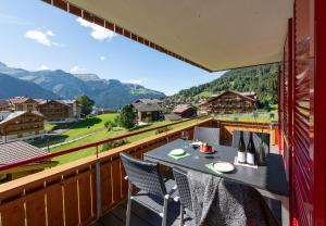a balcony with a table and chairs and mountains at Chalet Bargsunna in Wengen