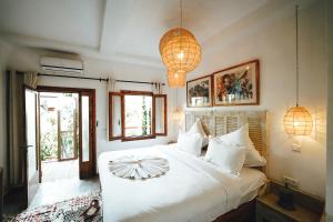 a bedroom with a white bed and two lamps at La Ferme Medina in Marrakech