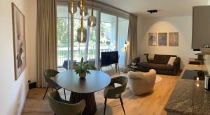 een woonkamer met een tafel en stoelen en een bank bij My Marina Apartment mit Pool und Sauna am See in Bad Saarow