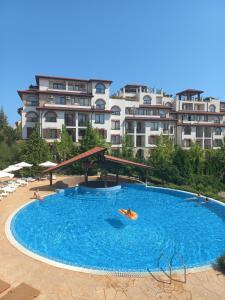 スヴェティ・ヴラスにあるParadise dreams family apartamentsの大型プール(建物の前で泳ぐ人々あり)