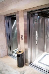 a trash can sitting in front of an elevator at Apartments Millennium InnMendoza in Mendoza