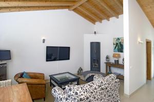 sala de estar con 2 sofás y TV en Casa Sereia Mar, en Salema