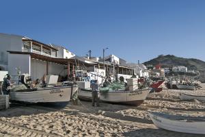 un grupo de barcos sentados en la playa en Casa Sereia Mar, en Salema