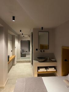 a bedroom with a bathroom with a sink and a mirror at EJ Boutique Suites in Milina