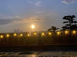 a fence with lights in front of a sunset at A tranquil mountain escape, casa particular, exclusive accommodation, private pool and terraces in Oria