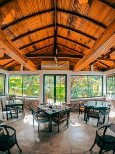 Habitación grande con mesas, sillas y ventanas. en Hill Safari - Tea Estate Villa, en Ohiya