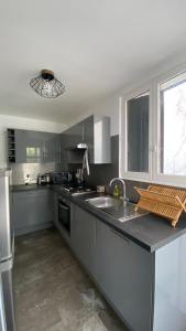 - une cuisine avec un évier et un comptoir dans l'établissement Appartement spacieux proche de paris, à Carrières-sur-Seine