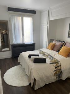 Un dormitorio con una cama grande y una ventana en Appartement spacieux proche de paris, en Carrières-sur-Seine