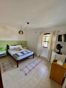 a bedroom with a bed and a large window at Casa Petrópolis in Petrópolis