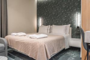 1 dormitorio con 1 cama con 2 toallas en Piazza Luxury Apartments, en Tirana