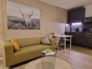 una sala de estar con sofá y una vaca en la pared en Urban City Lifestyle Appartement en Bielefeld