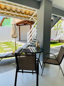 a dining room with a glass table and two chairs at Charlotte House in Canoa Quebrada