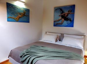 um quarto com uma cama com duas fotografias na parede em La piazza al lago - A 40 metri dal lago em Mandello del Lario