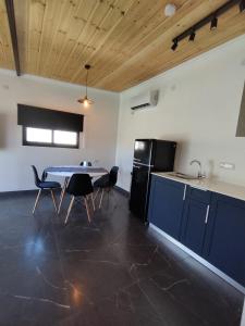 a kitchen with a table and chairs and a refrigerator at סוויט ריזורט בגורן in H̱osen