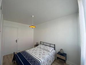 1 dormitorio con cama y pared blanca en Bel appartement centre ville de Vierzon, en Vierzon