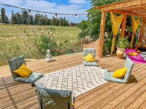 una terrazza in legno con sedie e gazebo di Alternativa Glamp a Ma‘yan Ẕevi