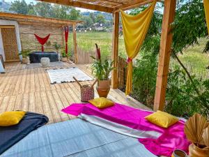 un patio con una mesa con sábanas rosas y amarillas en Alternativa Glamp, en Ma‘yan Ẕevi