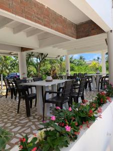 uma fila de mesas e cadeiras num pátio com flores em Casa de las Flores tropical em San Andrés