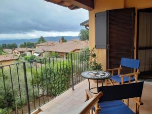 a balcony with a table and chairs and a view at Finestra Della Val D'Orcia in Contignano