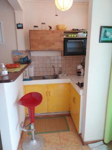 a small kitchen with a sink and a red stool at GITE LE FILAO in Le Lorrain