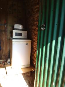 a microwave sitting on top of a small refrigerator at Retro caravan 