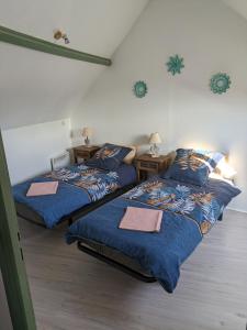 a bedroom with two beds and two night stands at Appartement pour 2 personnes in Annequin