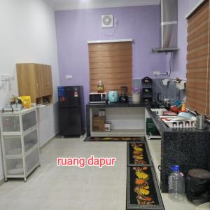 a kitchen with a refrigerator and a counter top at Raptronics Homestay Kampung in Kota Bharu