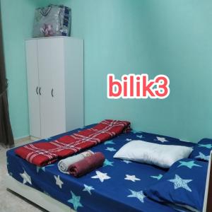 a bedroom with a bed with stars and white pillows at Raptronics Homestay Kampung in Kota Bharu