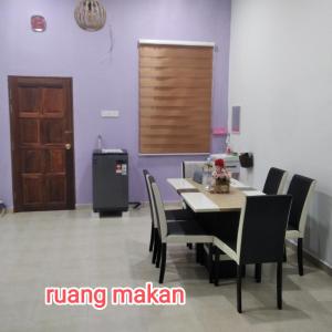 a dining room with purple walls and a table and chairs at Raptronics Homestay Kampung in Kota Bharu