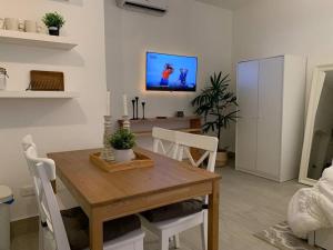 una sala da pranzo con tavolo e TV a parete di Cozy Apartment at The Village a Punta Cana