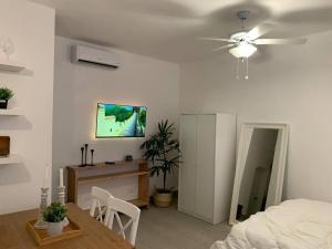 um quarto com uma cama, uma mesa e uma ventoinha de tecto em Cozy Apartment at The Village em Punta Cana