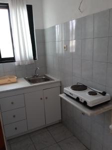 uma pequena cozinha com um fogão e um lavatório em PANAGIOTIS em Pefki