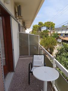 a balcony with a table and a chair on a balcony at PANAGIOTIS in Pefki +11 photos